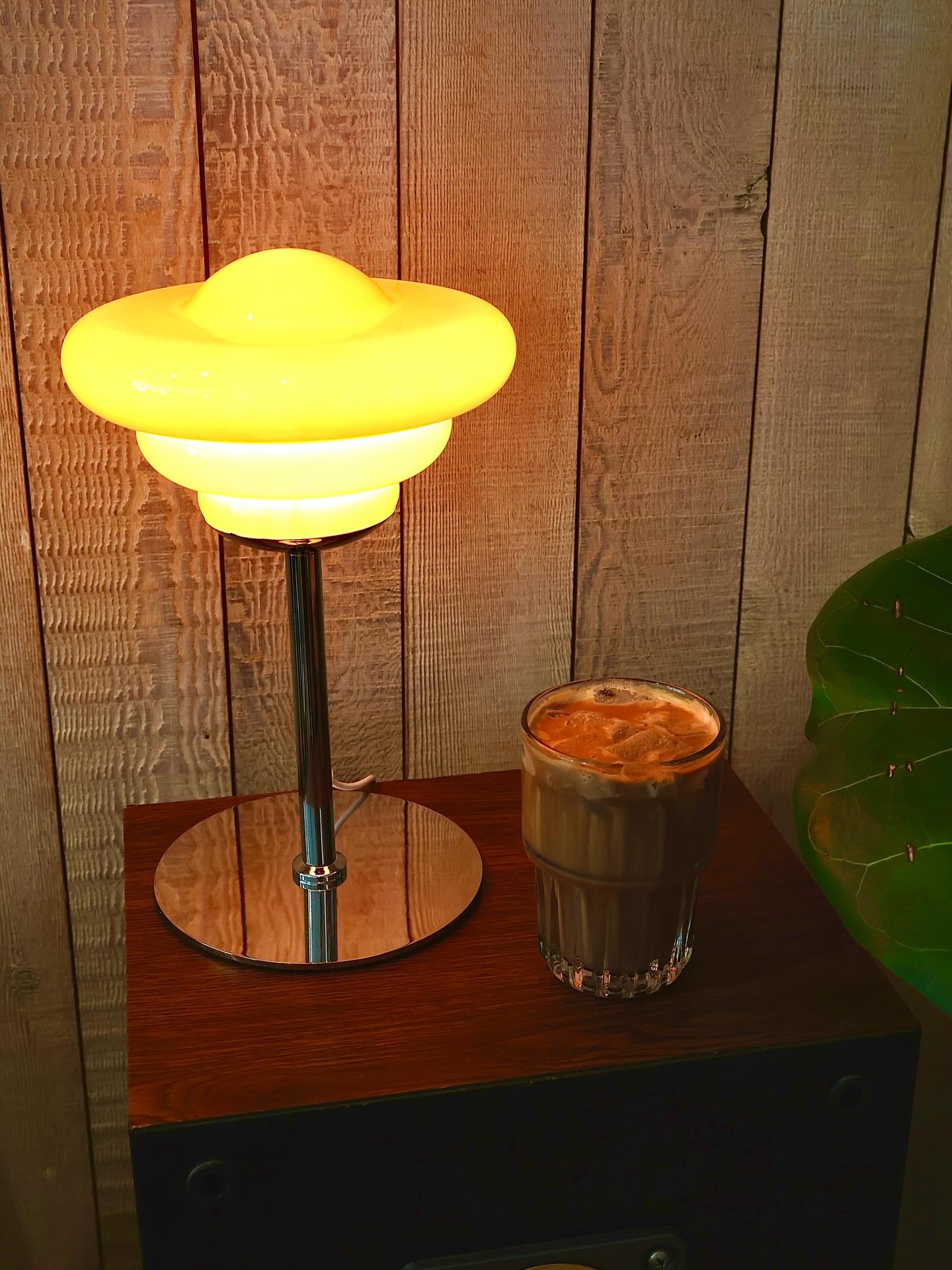 Iced latte beside a warm vintage lamp
